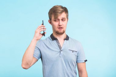 Yakışıklı adam yorgun ve rahatsız bir görünüm ile telefondan uzak bir obsesif ve can sıkıcı insanlar şikayet uzak taşımaya çalışıyor onun kulağına alır