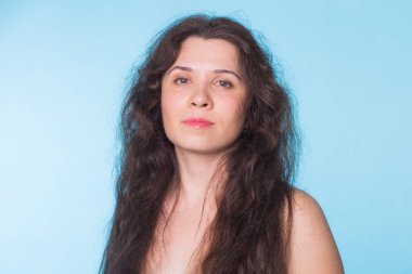 Mavi zemin üzerine kıvırcık saçlı seksi çıplak kadın portresi