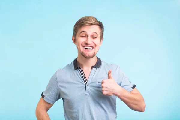 Uomo felice dando pollice su segno - ritratto su sfondo blu — Foto Stock