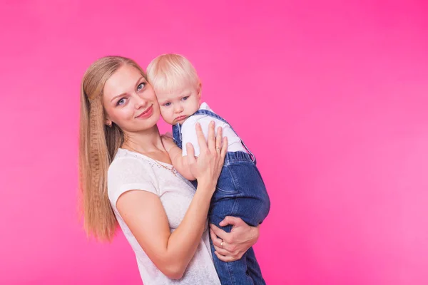 Feliz niña y su madre divirtiéndose sobre fondo rosa — Foto de Stock