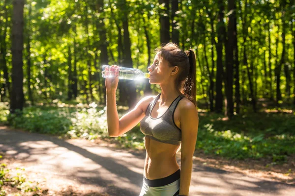 Jeune femme buvant de l'eau après avoir couru dehors — Photo
