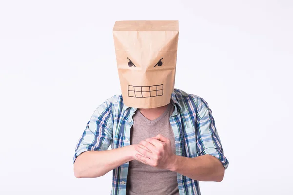 Muž s krabici na jeho hlavu a výkresu naštvaný smajlík tváře. Rozhněvaný muž začíná boj. — Stock fotografie