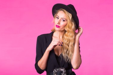 Stil, insanlar ve lüks konsepti - siyah şapka giyen güzel beyaz kadın. Moda stüdyo portre pembe bir arka plan üzerinde