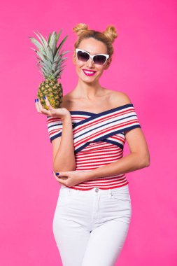 Güneş gözlüğü ve pembe bir arka plan üzerinde ananas ile kadın moda portre