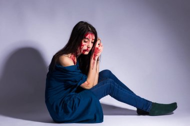 Kan ve vücut, cinsel şiddet, cinsel istismar, çürük ile zeminde oturan genç kadın insan ticareti