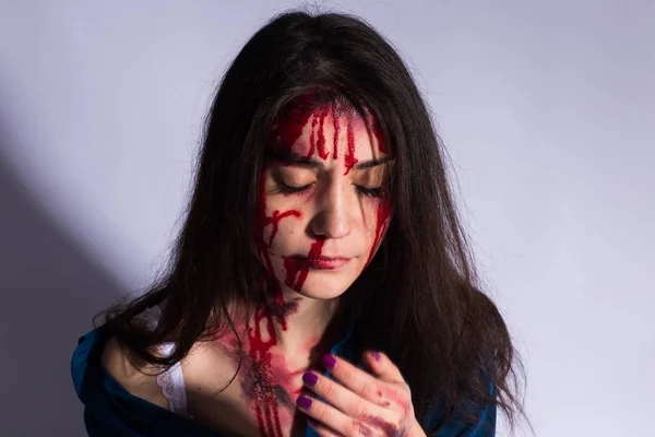 Uma jovem espancada com hematomas e sangue no rosto. Conceito de abuso e violência — Fotografia de Stock