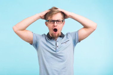 Mavi zemin üzerine şok veya sürpriz genç adam