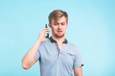 Yakışıklı adam yorgun ve rahatsız bir görünüm ile telefondan uzak bir obsesif ve can sıkıcı insanlar şikayet uzak taşımaya çalışıyor onun kulağına alır