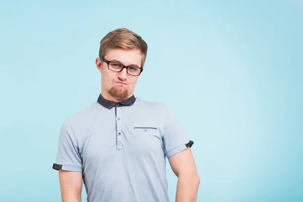 Giovane uomo divertente indossa occhiali isolati su sfondo blu. barbuto wonk sembra offeso . — Foto Stock