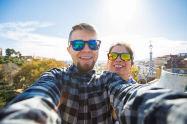 Çift selfie portre Park Guell, Barselona, İspanya, smartphone ile konuşmak mutlu seyahat. Güzel genç çift kamera ile akıllı telefon aşık gülümseyen fotoğrafı çekmek