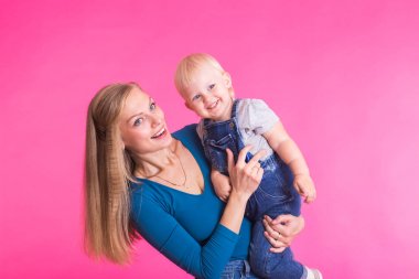 genç anne ve kızı birlikte eğleniyor arka plan pembe