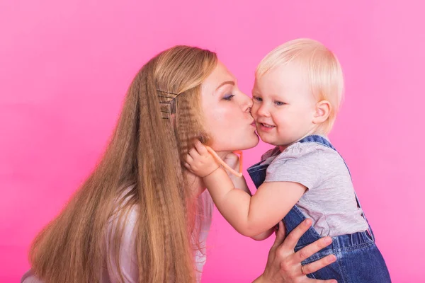 Anne ve kızı, pembe arka plan izole eğleniyor — Stok fotoğraf