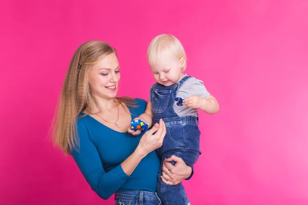 Familia divertida sobre fondo rosa. Madre y su hija. Mamá y el niño se están divirtiendo . — Foto de Stock