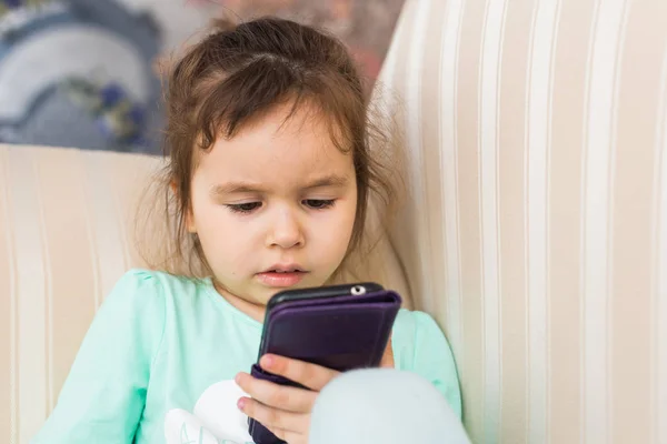 Linda niña usando un teléfono inteligente moderno —  Fotos de Stock