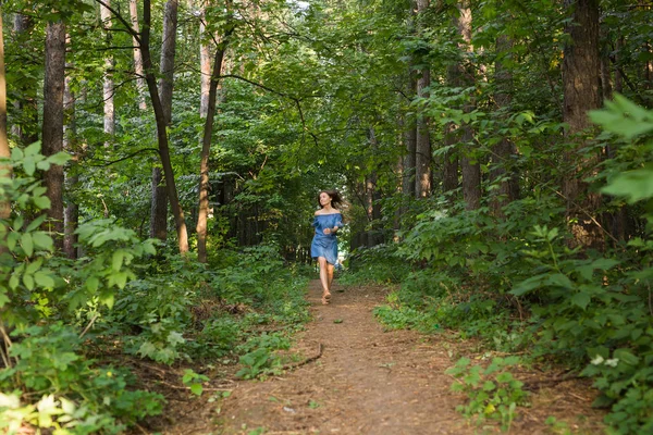Mooie jonge vrouw in jurk runing in het forest van de zomer — Stockfoto