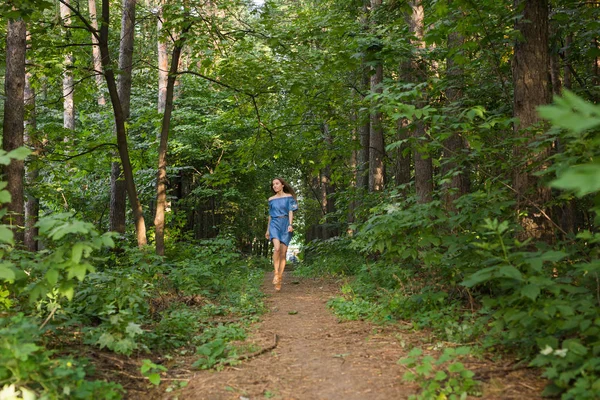 Belle jeune femme en robe qui court dans la forêt d'été — Photo