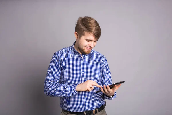 Человек с помощью планшета на сером фоне . — стоковое фото