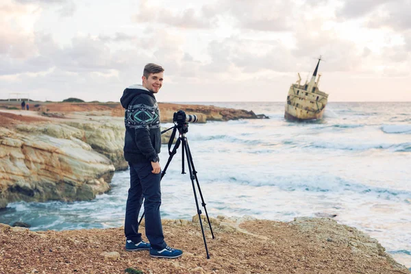 Joven fotógrafo con mochila haciendo fotos de mar y rocas con la cámara. Mar Mediterráneo — Foto de Stock