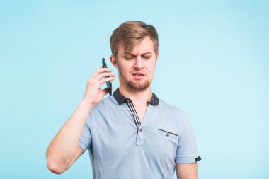 Yakışıklı adam yorgun ve rahatsız bir görünüm ile telefondan uzak bir obsesif ve can sıkıcı insanlar şikayet uzak taşımaya çalışıyor onun kulağına alır