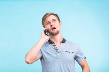 Gülümseyen adam arka plan mavi bir cep telefonu üzerinde bahsediyoruz