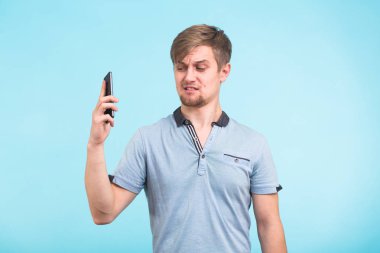 Yakışıklı adam yorgun ve rahatsız bir görünüm ile telefondan uzak bir obsesif ve can sıkıcı insanlar şikayet uzak taşımaya çalışıyor onun kulağına alır