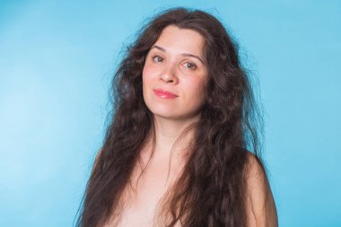 Mavi zemin üzerine kıvırcık saçlı seksi çıplak kadın portresi