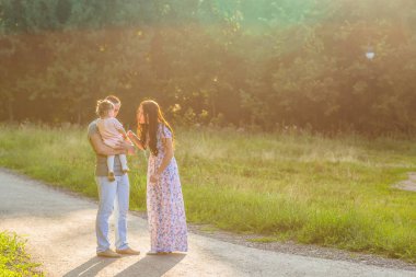 Mutlu karışık yarış aile açık hava etkinliği. Anne ve bebek kızı eğleniyor ve yaz Park'ta yürüyordunuz.