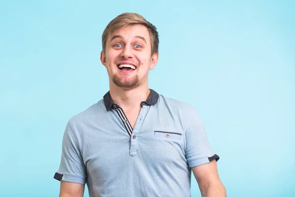 Homem excitado exclamou em felicidade, gestos ativamente, expressou grande surpresa, sobre fundo azul — Fotografia de Stock