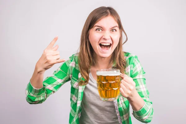 Весела молода жінка тримає пивний кухоль повний пива і посміхається на білому тлі — стокове фото