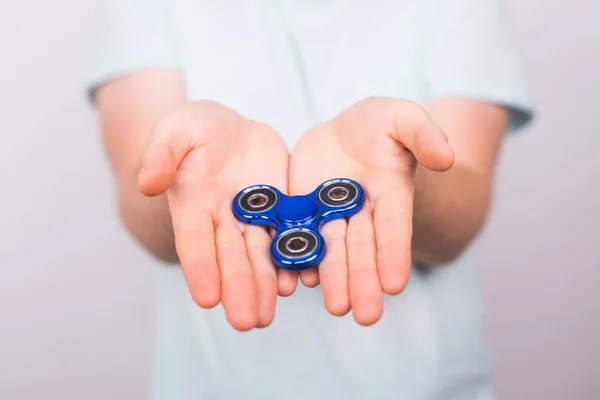 Mannelijke hand met populaire fidget spinner speelgoed op witte achtergrond, angst opluchting speelgoed, anti stress en ontspanning onrustig — Stockfoto