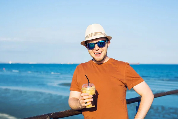 Hombre con frappe de café cerca del mar sintiéndose libre disfrutando de vacaciones en tiempo libre — Foto de Stock