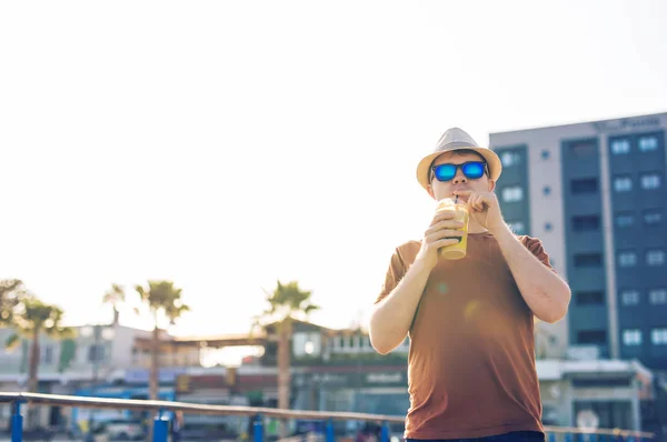 Styl życia, napoje i ludzi pojęcie - człowiek w okulary picia kawa frappe z zewnątrz filiżanki jednorazowe papierowe — Zdjęcie stockowe