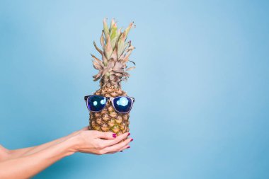 Moda Hipster ananas. Parlak yaz rengi, aksesuarlar. Tropikal meyve boşaltmak mavi zemin üzerine