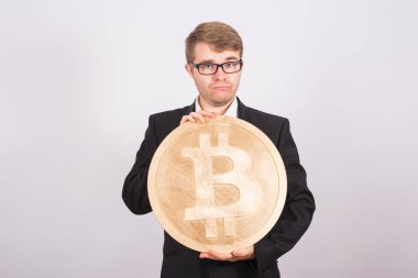 Büyük altın bitcoin, pembe arka plan tutan Businessnan. Kripto para birimi, sanal para, internet ve ekonomi kavramı