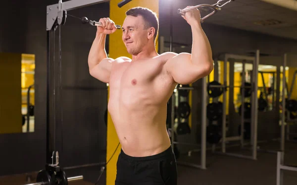 Mladý pohledný muž trénink v tělocvičně — Stock fotografie