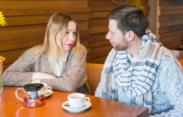 Счастливая молодая пара разговаривает и пьет кофе и улыбается сидя в кафе . — стоковое фото