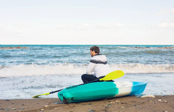 Hombre sentado en kayak en la playa del mar — Foto de Stock