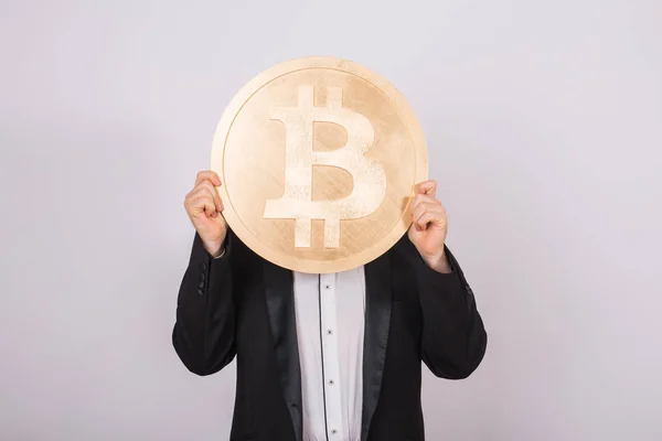 Geschäftsmann, der große goldene Bitcoins auf rosa Hintergrund hält. Kryptowährung, virtuelles Geld, Internet und Wirtschaftskonzept — Stockfoto