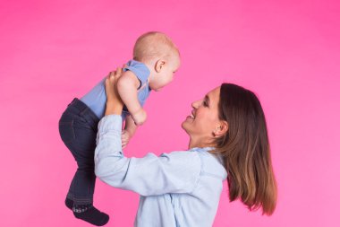 mutlu genç anne bebek çocuk üzerinde pembe bir arka plan ile
