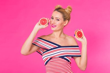 Büyük gıda sağlıklı bir yaşam tarzı için. Turuncu parça pembe arka planda tutan güzel genç kadın