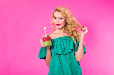 Boşaltmak pembe zemin üzerine yeşil güler yüzlü genç güzel kadın