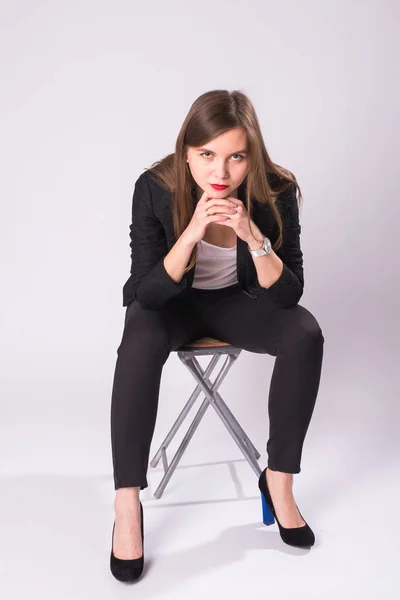 Modelo femenino atractivo caucásico con cabello moreno posando en estudio, usando traje formal aislado sobre fondo blanco — Foto de Stock