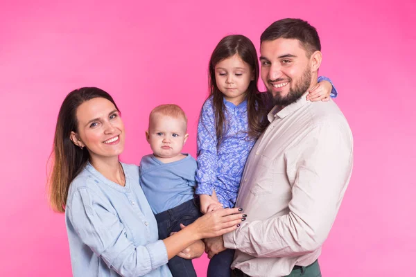 Feliz retrato familiar de raza mixta sonriendo sobre fondo rosa — Foto de Stock