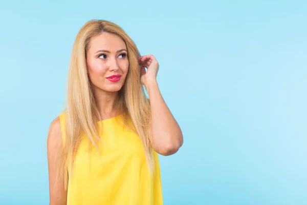 Portret van lachende blonde vrouw in modieuze blik op blauwe achtergrond met copyspace. Stijl, fashion, zomer en mensen concept — Stockfoto