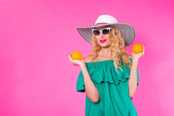 Piękna kobieta stylowe okulary przeciwsłoneczne i kapelusz z pomarańczy, zabawy na różowym tle z lato — Zdjęcie stockowe