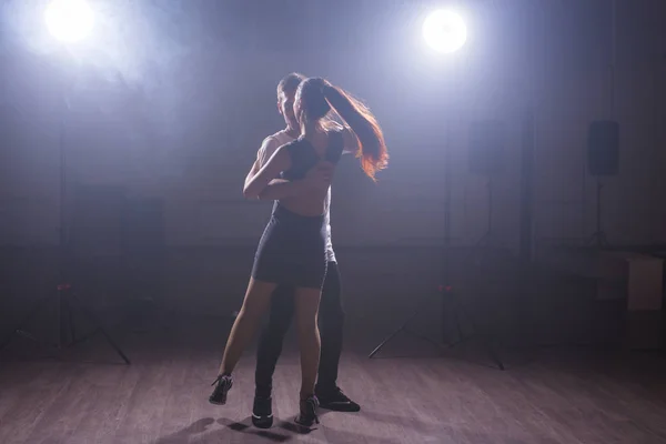 Pareja joven bailando baile latino Bachata, merengue, salsa. Dos poses de elegancia en clase de baile — Foto de Stock