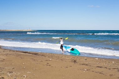 Kayık deniz Plajı'nda taşıyan adam