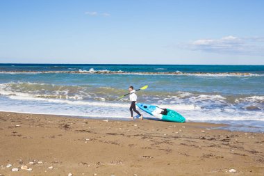 Kayık deniz Plajı'nda taşıyan adam