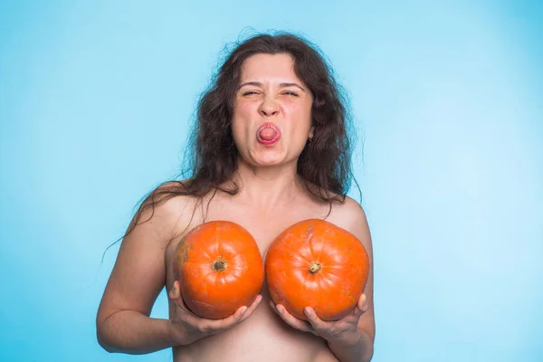 Koncepcja implantu piersi - szczęśliwa kobieta posiadający dwa dynie przed jej piersi — Zdjęcie stockowe