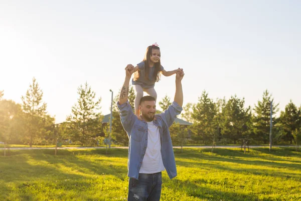 Heureux père homme tenant sa petite fille sur le cou dans le parc d'été — Photo